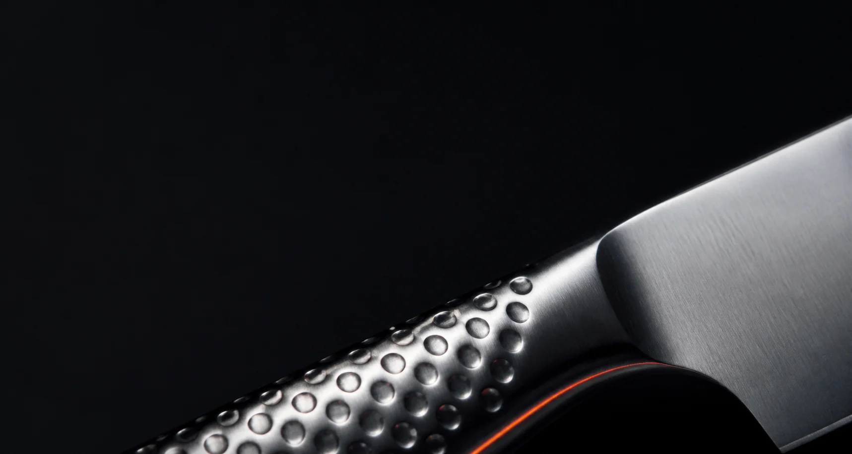 Macro detail of a dimpled stainless knife handle and blade